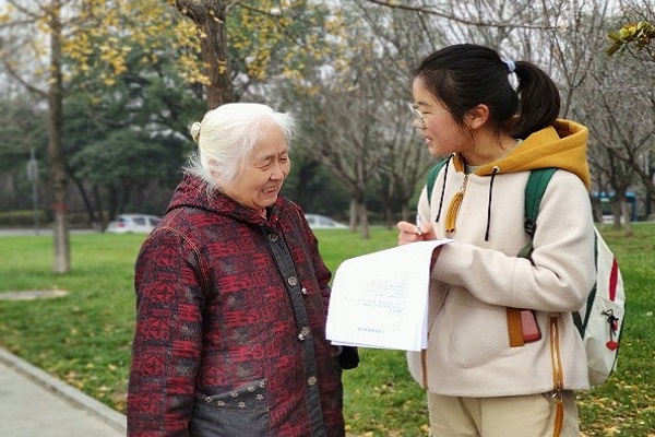 4aad7aee70324e9e9bfa9ae7dc0a1c46.jpg 志愿者为校外群众发放调查问卷.jpg